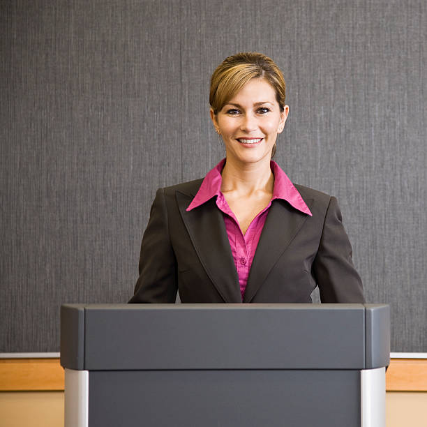 Smiling Businesswoman At Podium stock photo