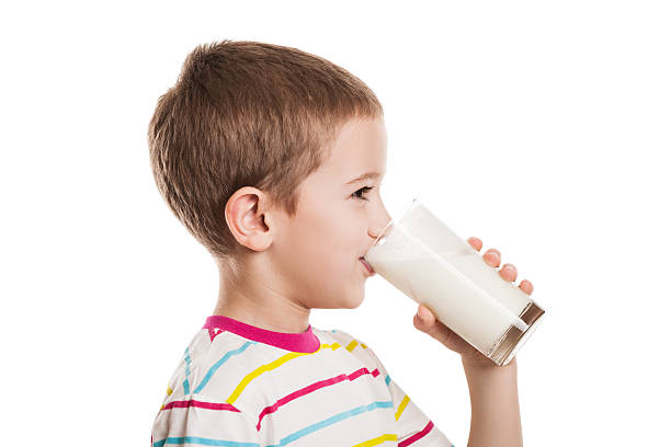 Smiling child boy drinking milk stock photo