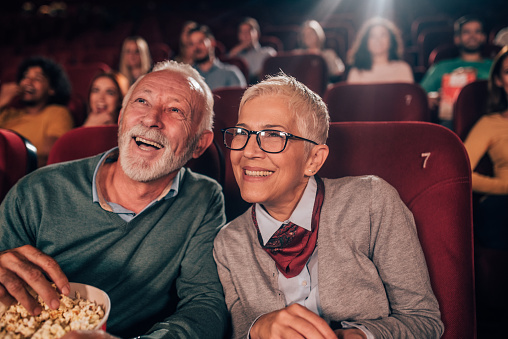 Happy senior couple having a snack in the cinema