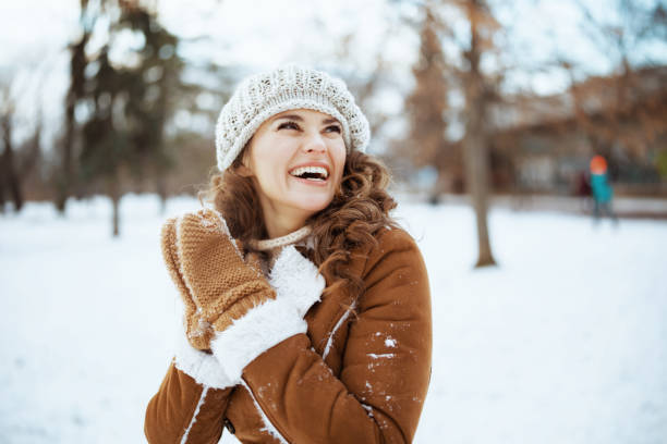 smiling elegant woman outside in city park in winter stock photo