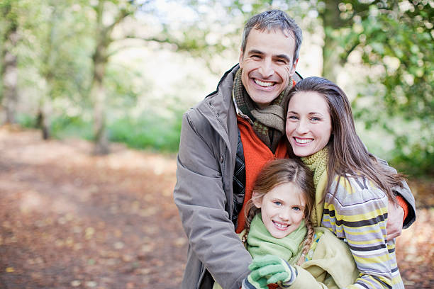 smiling family hugging outdoors - happy couple cold stockfoto's en -beelden