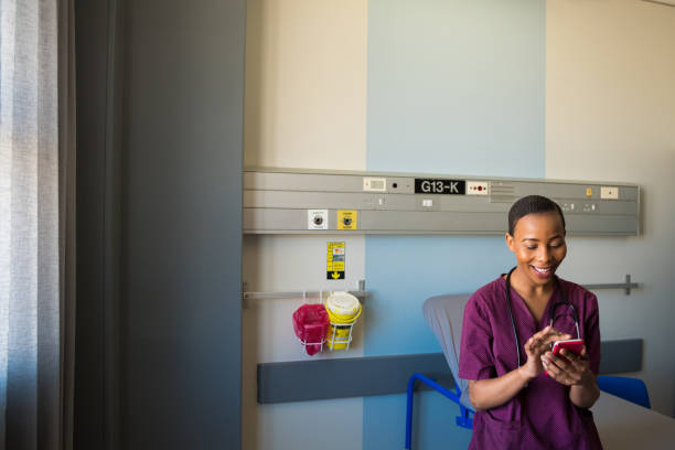 leende kvinnlig sjuk sköterska använder telefonen i sjukhusavdelningar - happy scrubs nurse phone bildbanksfoton och bilder