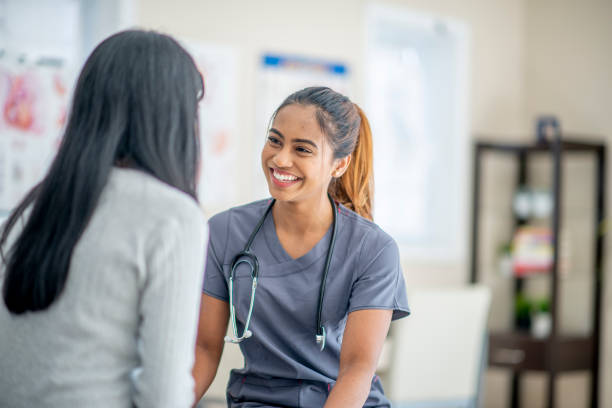 Smiling Female Nurse With A Patient At A Medical Check Up Appointment stock photo
