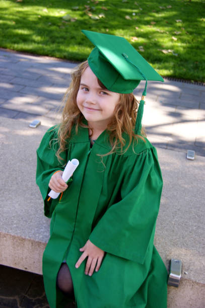 Smiling girl dressed for kindergarten graduation stock photo