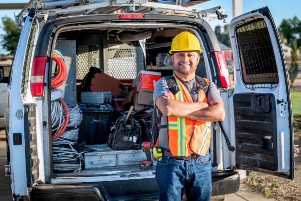 Smiling hispanic construction worker wearing a work helmet looking at the camera stock photo