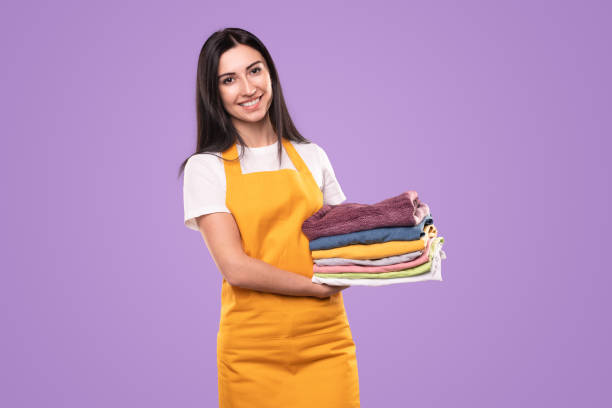 Smiling housewife with washed laundry stock photo