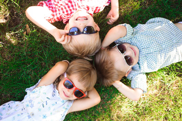 Smiling kids at the garden in sunglasses stock photo
