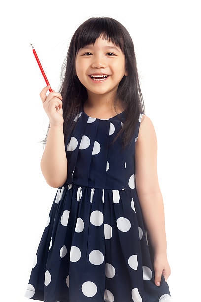 Smiling little girl holding pencil stock photo