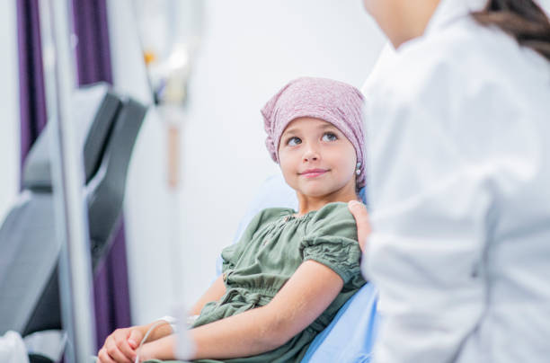 Smiling Little Girl With Cancer stock photo A little girl shares a smile with her female Doctor at her bedside childhood stock pictures, royalty-free photos & images