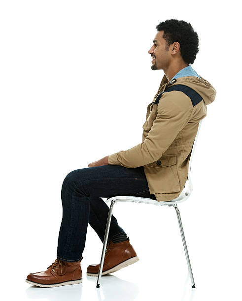 Smiling man on chair and looking away stock photo