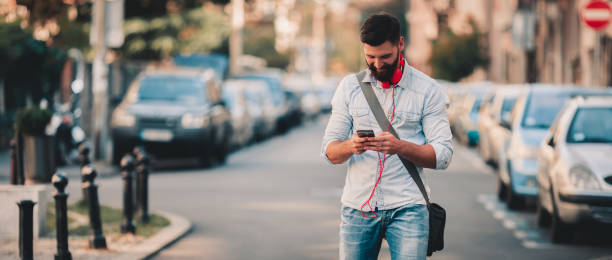 Smiling man texting on the street stock photo