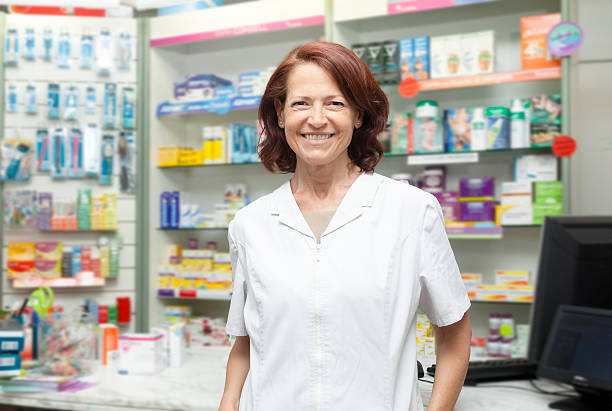 Smiling mature professional pharmacist at her store stock photo