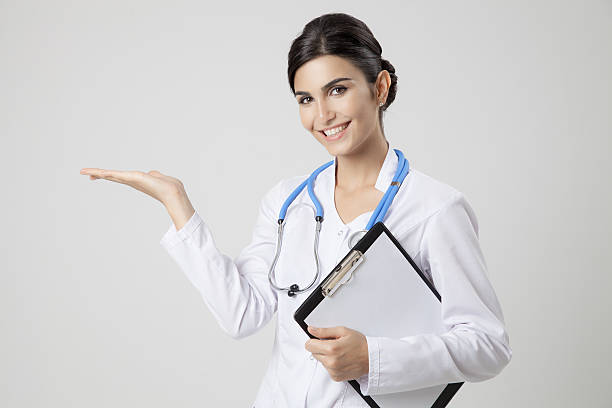 Smiling medical doctor woman with stethoscope. Present something stock photo
