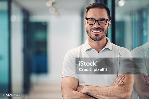 istock Smiling mid adult man in polo shirt 1373240842