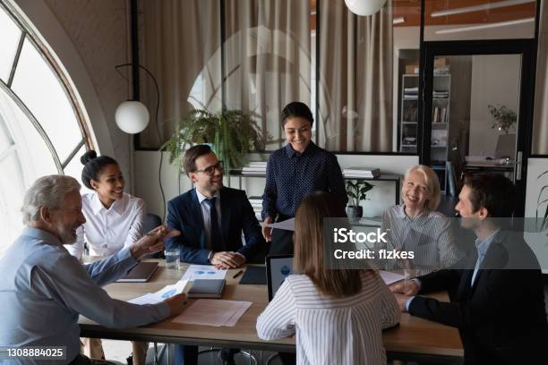 Smiling multiethnic diverse colleagues brainstorm at group meeting