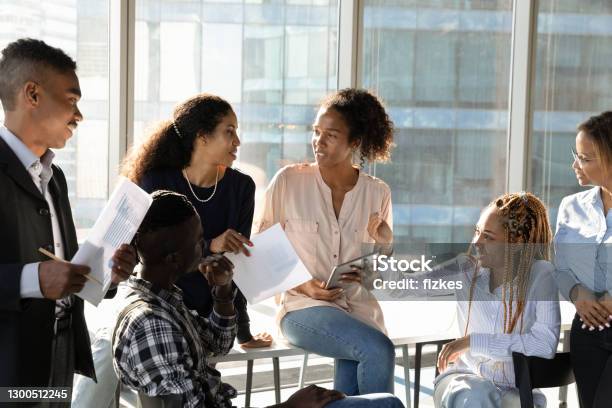 Smiling multiethnic employees brainstorm at meeting in office