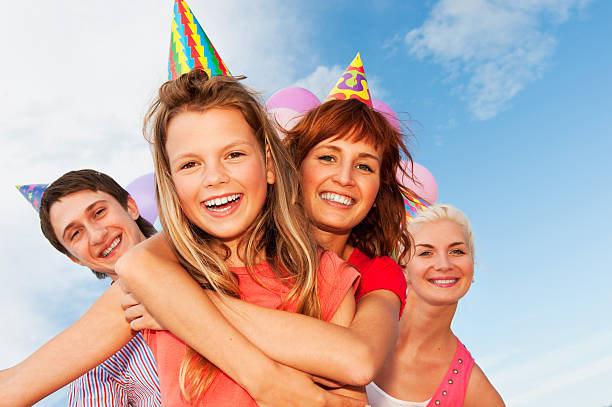 Smiling people wearing party hats having a celebration stock photo