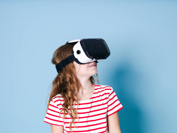 smiling positive girl wearing virtual reality glasses goggles headset, vr box stock photo