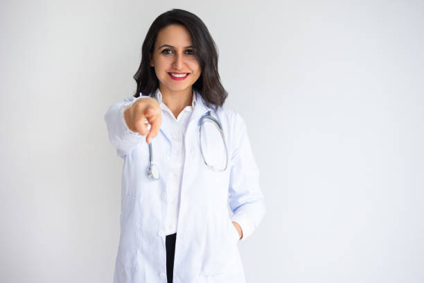 Smiling Pretty Female Doctor Pointing at You stock photo