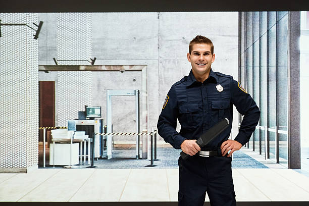 Smiling security guard standing indoors stock photo