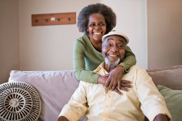 Smiling senior couple in living room at home stock photo