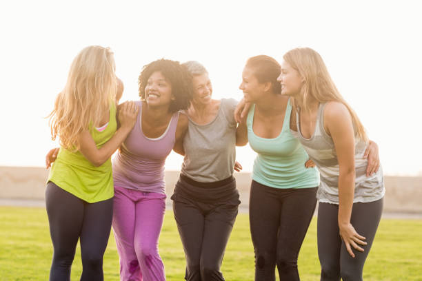 Smiling sporty women with arms around each other Smiling sporty women with arms around each other in parkland 30 39 years stock pictures, royalty-free photos & images