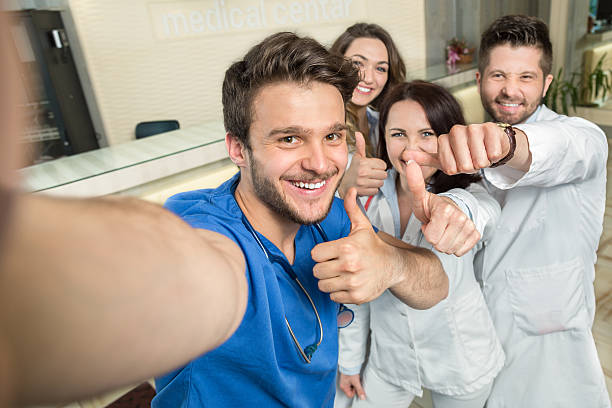 Smiling Team Of Doctors And Nurses At Hospital Taking Selfie stock photo