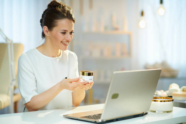 smiling woman employee in beauty studio having video chat stock photo