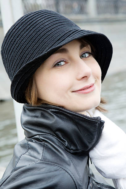 smiling woman in black hat stock photo