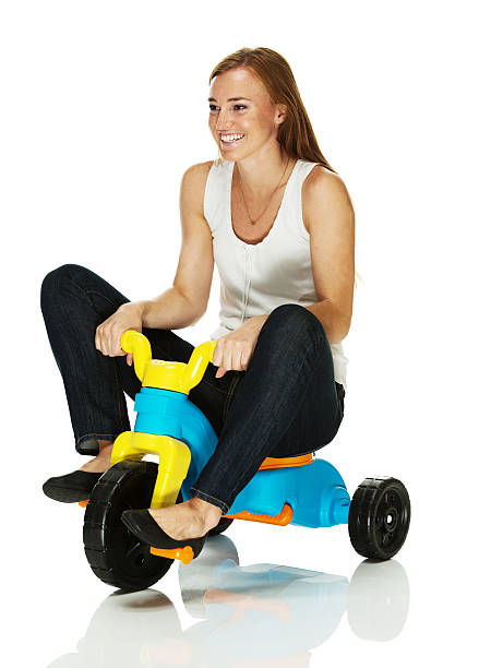 Smiling woman riding a tricycle Smiling woman riding a tricyclehttp://www.twodozendesign.info/i/1.png adult tricycle stock pictures, royalty-free photos & images