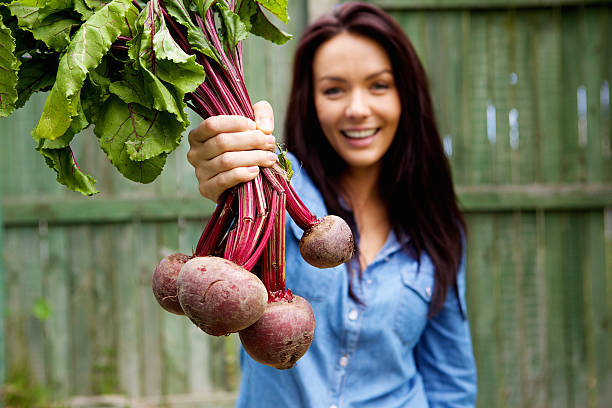 Smiling woman showing a bunch of beetroots stock photo