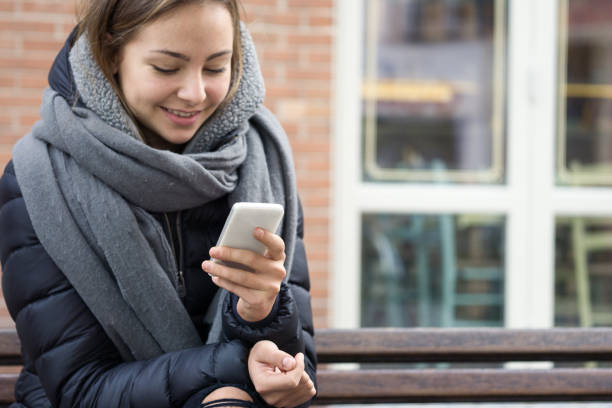 smiling woman using mobile phone  outdoors stock photo