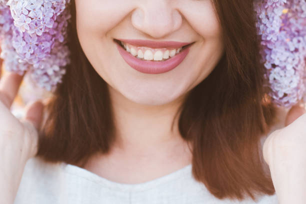 Smiling woman with flowers outdoors stock photo