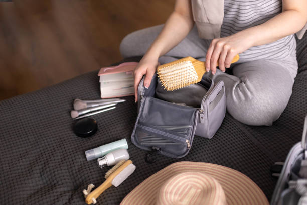 Smiling woman writing list of necessary cosmetics getting ready trip vacation storage organization stock photo
