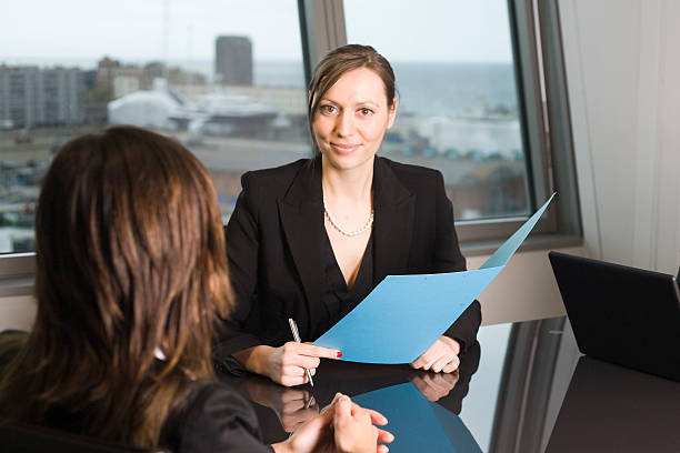 A smiling young business woman holding open a blue folder stock photo