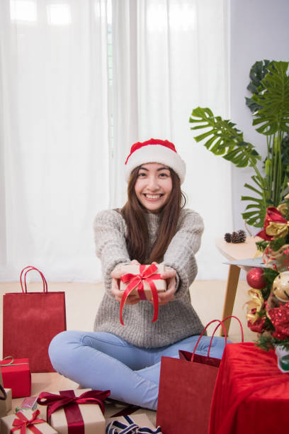 leende ung kvinna leverera rutan jul närvarande. - santa holding magazine bildbanksfoton och bilder