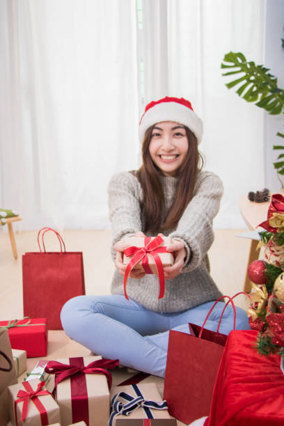 leende ung kvinna leverera rutan jul närvarande. - santa holding magazine bildbanksfoton och bilder