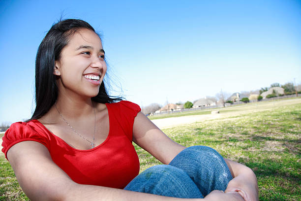 Smiling Young Woman Sitting at the Park, with Copy Space "Smiling Young Woman Sitting at the Park, with Copy Space.See more of this series:" mexican teenage girls stock pictures, royalty-free photos & images