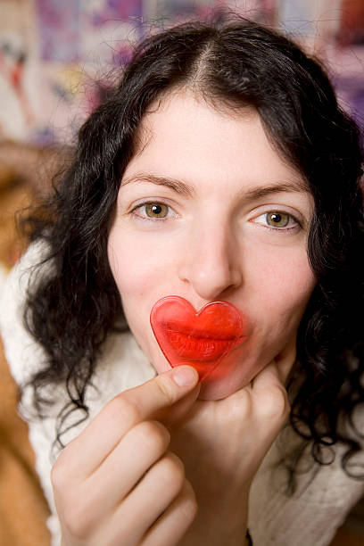 smiling young woman with plastic heart stock photo