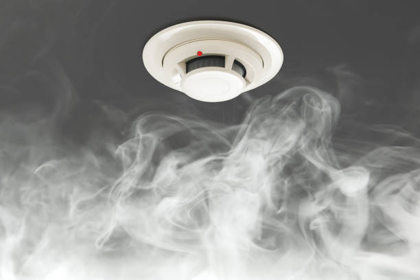 smoke detector on ceiling, fire alarm in action stock photo