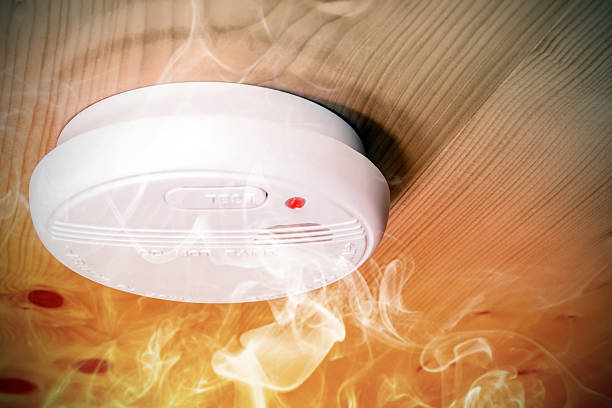smoke fire detected by home smoke detector alarm on ceiling - smoke alarm stockfoto's en -beelden
