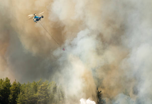 smoke rising from a forest fires of july-august 2021 in marmaris resort town of turkey, with kaumov ka-32 fire-fighting helicopter dumping water . - save water bucket stockfoto's en -beelden