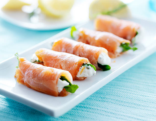 smoked salmon and arugala wrap with cream cheese on platter stock photo