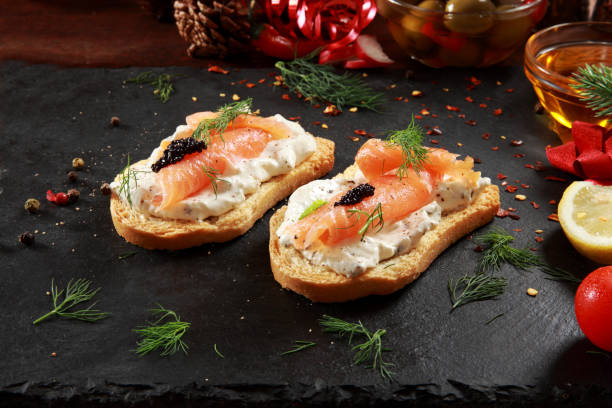 Smoked Salmon and Cream Cheese Canapes Smoked Salmon and Cream Cheese Canapes with festive decoration background smoked salmon photos stock pictures, royalty-free photos & images