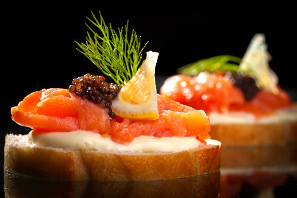 Smoked salmon and cream cheese croissant Nice sandwitch and croissant with lemon salmon and cheese on black background smoked salmon photos stock pictures, royalty-free photos & images