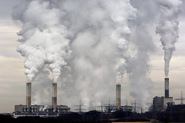 Smokestacks with pollution Smokestacks of a coal burning power plant with pollution on a cloudy day. air pollution stock pictures, royalty-free photos & images