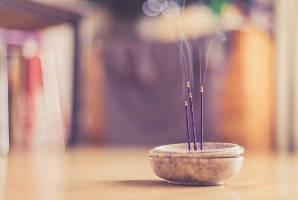 Smoking and smelling joss sticks at home, feng shui; Copy space stock photo