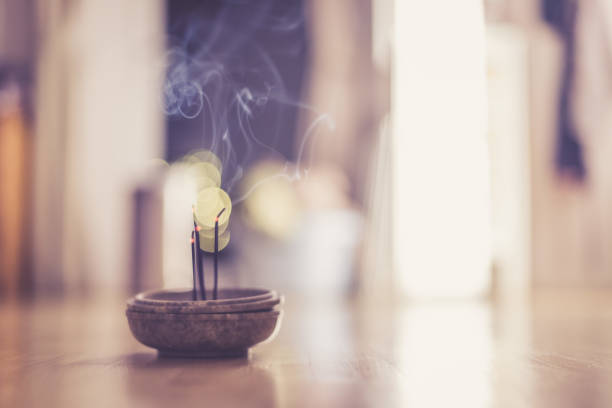 Smoking and smelling joss sticks at home, feng shui; Copy space stock photo