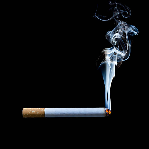 fumer une cigarette, sur fond noir - cigarette photos et images de collection