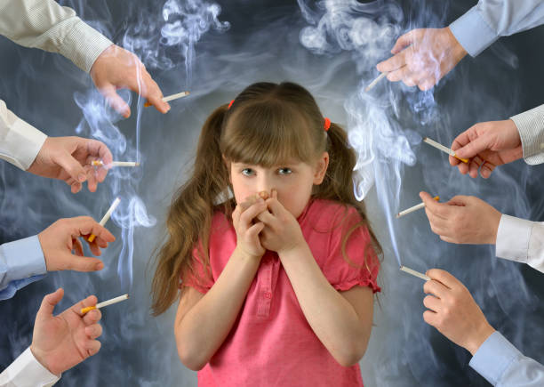 Smoking in front of the child kid .A little girl covers her nose from tobacco smoke.Conceptual photography.  little girl smoking cigarette stock pictures, royalty-free photos & images